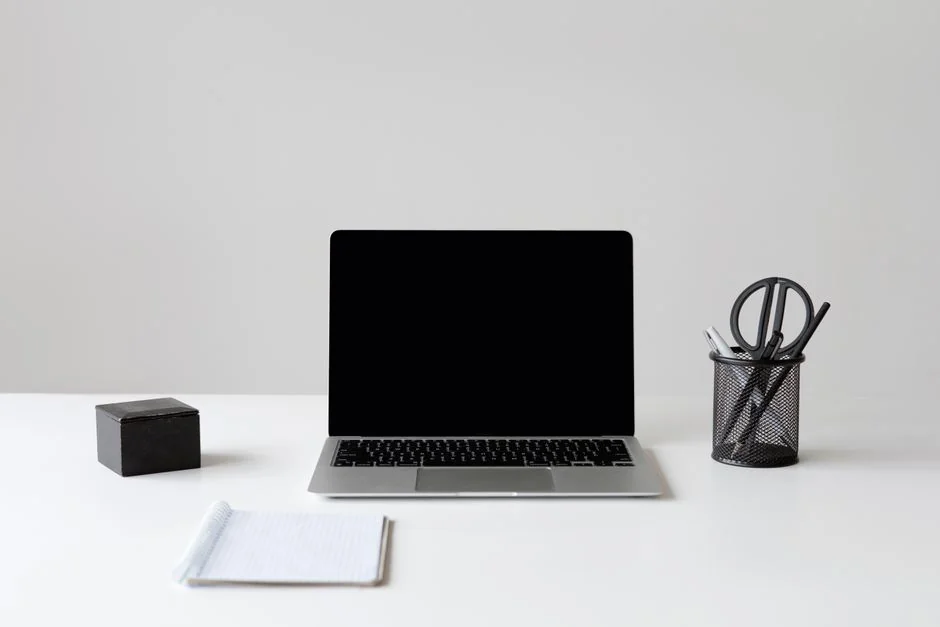 A sleek office desk setup featuring Apple devices: iMac, MacBook, and iPad.