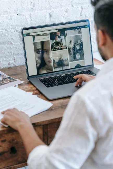 Dual monitors on a desk, showcasing web design in a modern office setting.